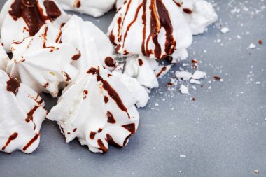 white meringues drizzled with dark chocolate on gray with selective focus