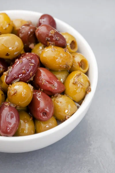 Mixed marinated olives on grey surface with copy space