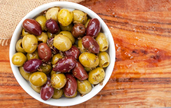 Mixed marinated olives on rustic wooden surface with copy space