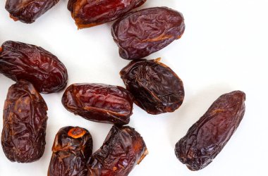 Beyaz arka planda izole edilmiş lezzetli, kurumuş tarihler.