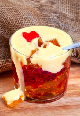 Jöle ve kremalı kaşık ve kırsal masaya damlayan çuval bezi.