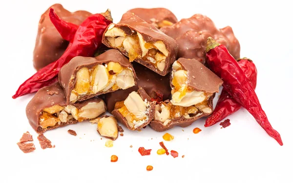 Chocolate covered peanut brittle pieces with chili, a spicy twist on white