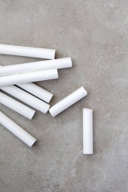 Gri arkaplanda düz beyaz tebeşir 