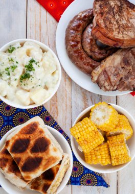 Güney Afrika Braai Günü veya Miras Günü. Geleneksel Braai yemeklerini kutluyoruz. Et ve kenarlar geleneksel Shwe-Shwe kumaşıyla..