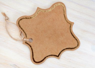 Boş karton hediye etiketi, aydınlık ahşap üzerinde izole edilmiş.