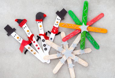  Buzlu çubuklu Noel el sanatları. Yıldız süsleri ya da kar taneleri olan küçük kardan adamlar.