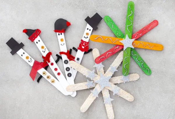 stock image  Christmas crafts with popsicle sticks. Tiny snowmen with Stars ornaments or snowflakes