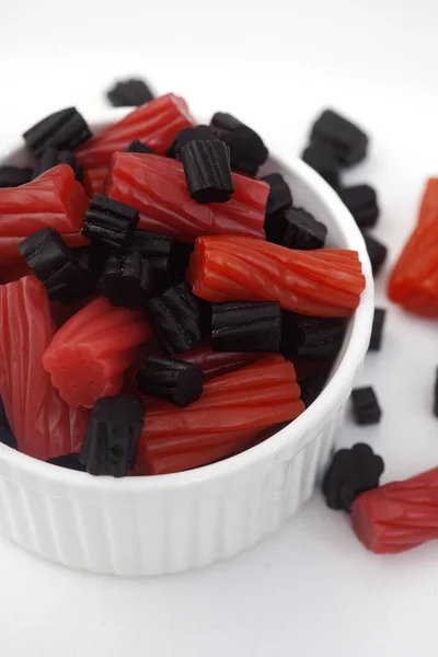 Bowl of mixed red and black licorice, top view with copy space