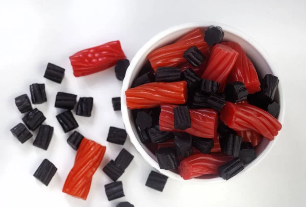Bowl of mixed red and black licorice, top view with copy space