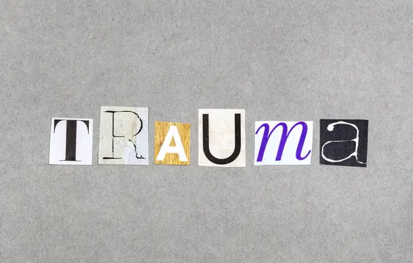Gri arka planda dergi parçalarında travma kelimesi var.