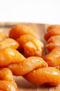 Altında ahşap bir masa olan geleneksel Güney Afrikalı Koeksisters tabağının yakın çekimi.