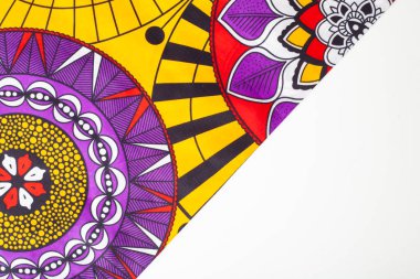 Sarı, mor ve kırmızı renkli parlak ve canlı bir balmumu kumaş.