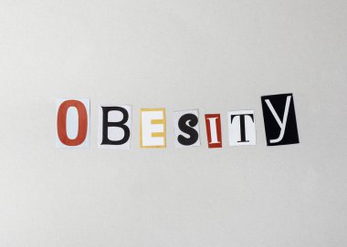 Obezite kelimesi dergi kesikleri kolajında yazılıdır. Dergi harflerinde Obezite açık griye yazılıyor. Bu, sağlıksız beslenme alışkanlıklarının olumsuz etkileri hakkında bir yorum olarak yorumlanabilir.