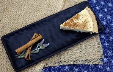 Güney Afrika sütlü turtası, buranın gözdesi. Siyah bir tabakta garnitürle servis edilmiş. Yüzeyde 