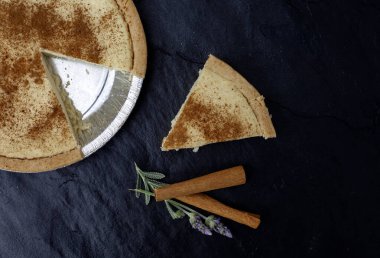 Güney Afrika 'nın tek bir dilimi' melktert 'siyah bir levha üzerinde biraz tarçın ve lavanta ile