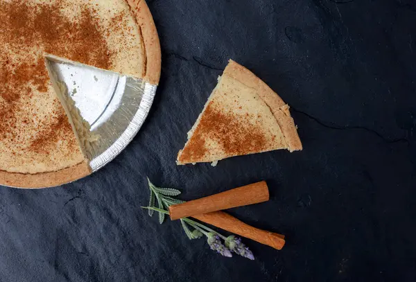 Güney Afrika 'nın tek bir dilimi' melktert 'siyah bir levha üzerinde biraz tarçın ve lavanta ile