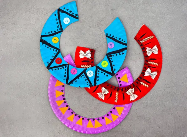 Çok dekoratif desenli Güney Afrika kolyelerine dönüştürülmüş kağıt tabaklar. Güney Afrika Mirasları Gündüz Sanatı