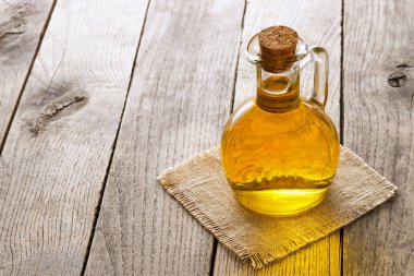 cooking oil in glass transparent bottle on wooden table