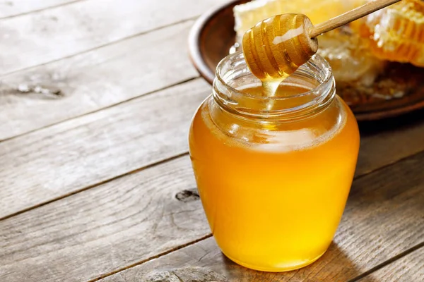 Glas Honig Mit Wabe Auf Holztisch Stockbild