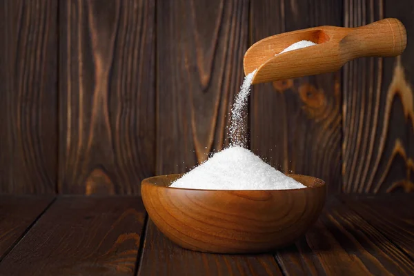 Weißer Zucker Sand Fällt Aus Schaufel Schüssel Auf Tisch Auf lizenzfreie Stockfotos