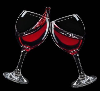 Kızartma jestinde iki kadeh kırmızı şarap ve siyah arka planda izole edilmiş sıçrama.