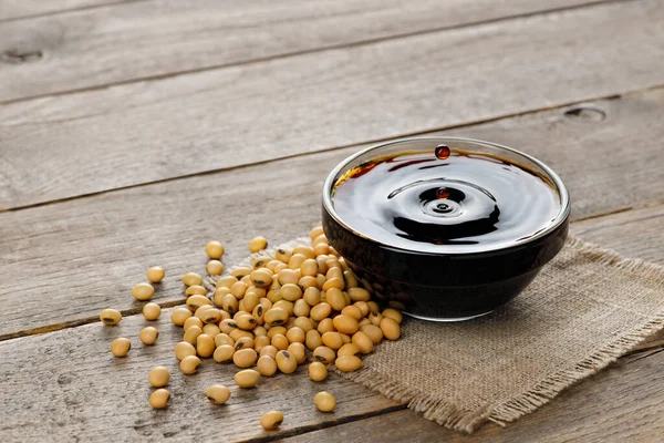 Soy Sauce Glass Bowl Falling Drops Dry Soybeans Gray Table — Stock Photo, Image