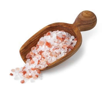 Himalaya tuzu beyaz arka planda izole edilmiş ahşap kepçeden dökülür..