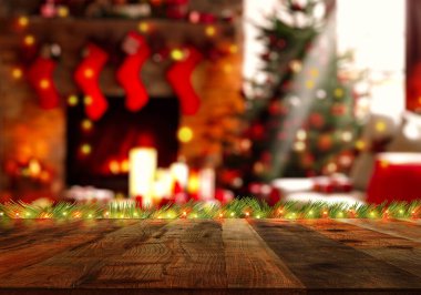 Bulanık bokeh Noel ağacının üstündeki boş tahta masa ve haber yılının süslemesi. İnternet afişi için Noel zamanını hesaplayın, ürünlerinizi gösterin ya da montajlayın. Sıcak renkler.