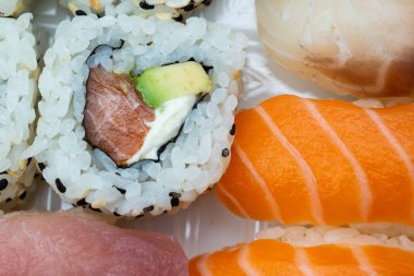 Somon nigiri, avokado rulo ve zencefilli garnitür içeren birinci sınıf suşi çeşitleri. Restoran menüleri, mutfak blogları, Japon mutfak pazarlaması ve yemek dağıtım uygulamaları için mükemmel..