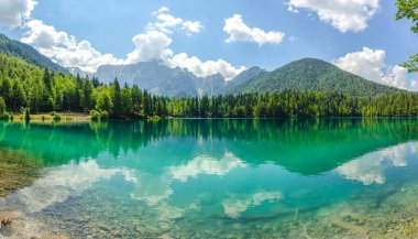 İtalyan Alplerinde mükemmel dağ yansımaları olan kristal berrak zümrüt göl. Çarpıcı panoramik manzara, el değmemiş vahşi doğa, dramatik zirveler ve seyahat için ideal canlı orman renkleri....