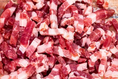 Taze doğranmış pastırma parçaları kırmızı et ve beyaz yağ mermerlerini gösteriyor. Yemek pişirme uygulamaları, restoran menüleri, yemek blogları ve mutfak içeriği yaratımı için mükemmel..