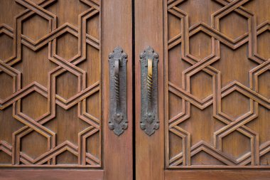 Lüks sürgülü ahşap kapıdaki pirinç kapı kollarına yakın çekim