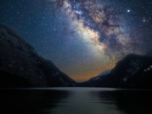 Milky Way galaxy with stars in the night sky with mountain and lake