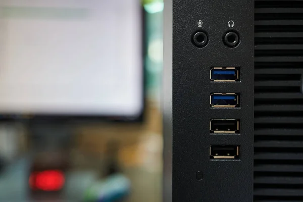 close up of a computer usb port with monitor in background