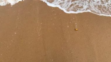 Gün içinde kumsaldaki deniz dalgalarının yavaş çekim görüntüleri.