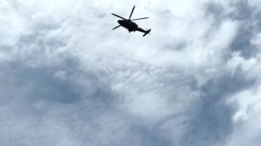 Bulutlu gökyüzü ile uçan helikopterin alçak açılı görüntüsü