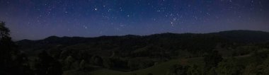 panorama view of mountain and starry sky at night time clipart