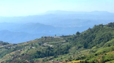 Dağlardan inen geniş bir yol ve araba manzarası var.