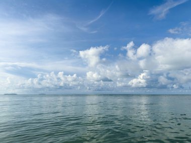 Bulutlu gökyüzü ile sakin deniz manzarası