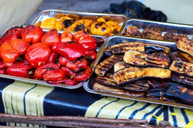 Yemek fuarında kırmızı ve sarı ızgara taze kavrulmuş dolma biber, mantar ve patlıcan. Sokak yemeği.