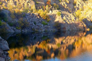 Radon Gölü eski terk edilmiş granit ocağında gün batımında saf şeffaf suyla dolu. Ukrayna, Migeia.