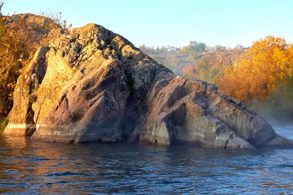 Vahşi dağ nehri, ıssız yerlerde kayalık kıyılarda akan akıntılar. Nehrin sonbahar sabahı manzarası