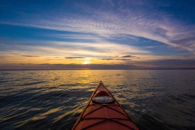 Gün batımında sakin gölde pruva kırmızı kano manzarası. Sonbaharda kayak yapmak