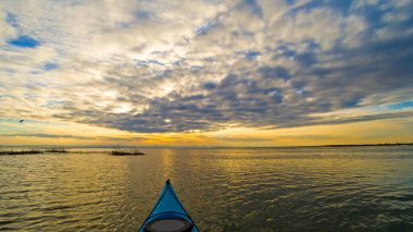 Gün batımında mavi kanonun pruvasından sonbahar gölüne bakın. Sonbahar ya da kış kanosu.