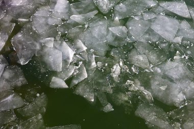 Buz gibi su yüzeyinde küçük buz kütleleri var. Buz gibi kış. Suyun katı hali. Üst görünüm - bahar arkaplanı veya doku. Su yüzeyinde çatlak buz yüzeyinin havadan görünüşü