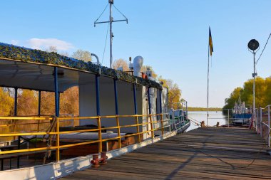 Nehirdeki ahşap bir iskelenin yanında geminin yan tarafında bir parça.