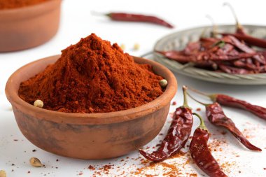 Kırmızı kırmızı biber, canlı bir baharat, sıcak kırmızı bir toz haline getirilir, yiyeceğe lezzet katmak için anahtar bir bileşendir.