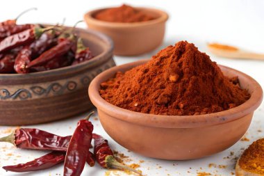 Kırmızı kırmızı biber, canlı bir baharat, sıcak kırmızı bir toz haline getirilir, yiyeceğe lezzet katmak için anahtar bir bileşendir.