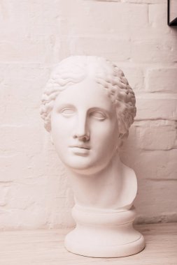 Heykelin alçı başı beyaz tuğla bir duvarın arka planında. Yüksek kalite fotoğraf