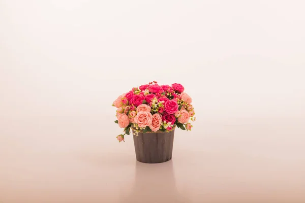 Bouquet of red and pink roses in a bucket on a light background. High quality photo